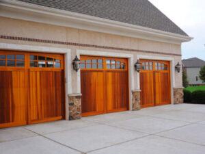 Three beautiful wooden single-car garage doors on a home.